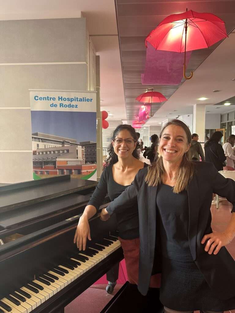 Les deux pianistes devant le piano dans le hall principal de l'hôpital