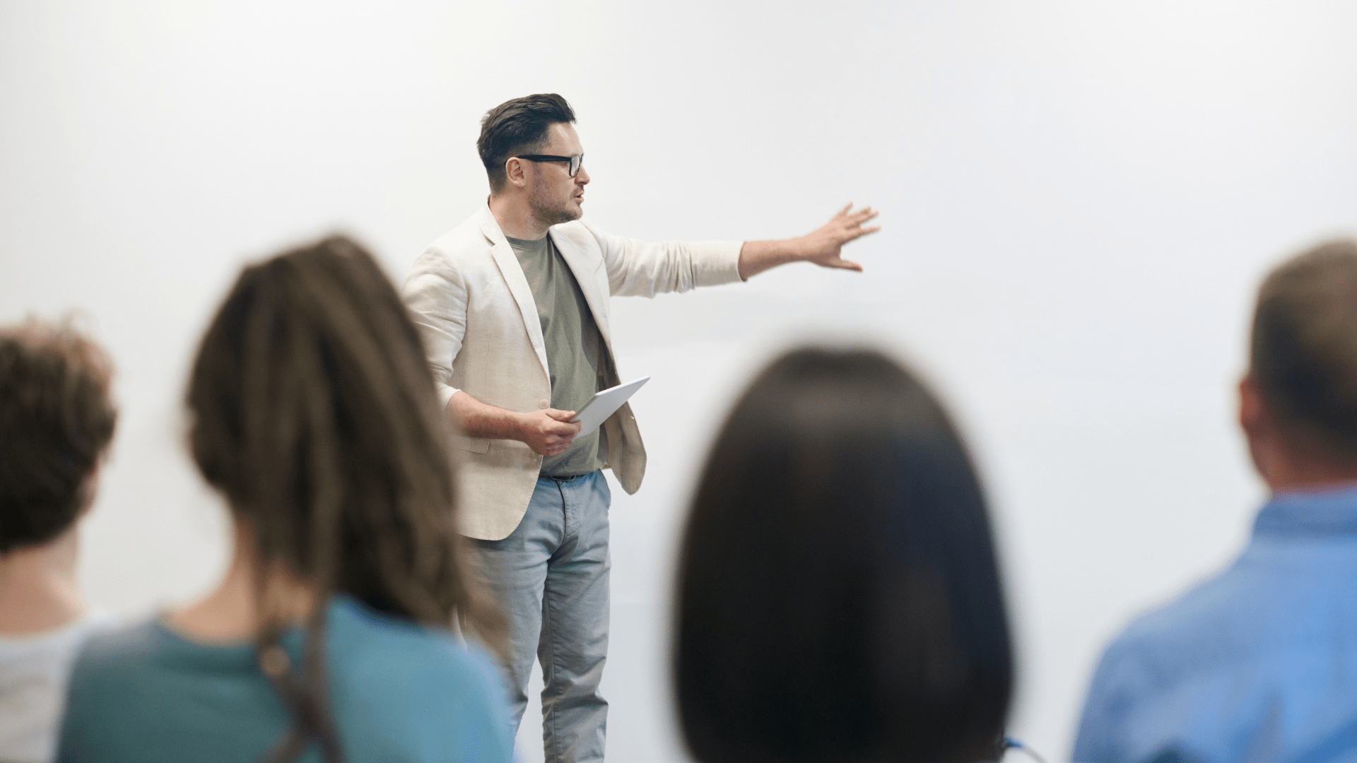 Une professeur devant une classe d'étudiants. Il est en train d'exercer un cours devant un tableau blanc.