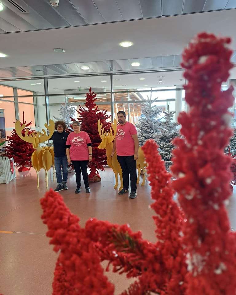 Membres de l'association TLMC devant les décors de Noël dans le hall de l'hôpital